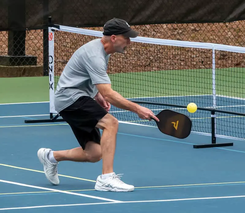 a player hitting a pickleball